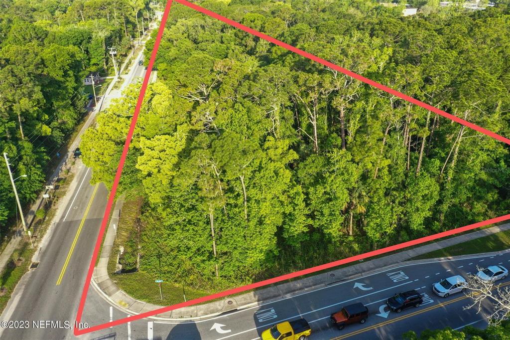 An aerial view shows a triangular, wooded plot of land bordered by two paved roads — 901 W KING STREET, ST AUGUSTINE, FL