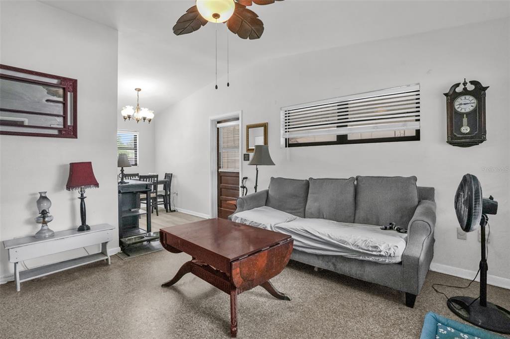 A living room features a gray sofa, a wooden coffee table, and a ceiling fan — 6409 RAMIR ROAD, ORLANDO, FL