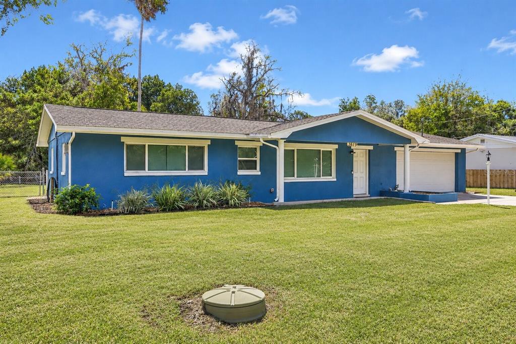 A blue single-story house with a white garage door sits on a grassy lawn — 3619 N SUWANNEE POINT, CRYSTAL RIVER, FL