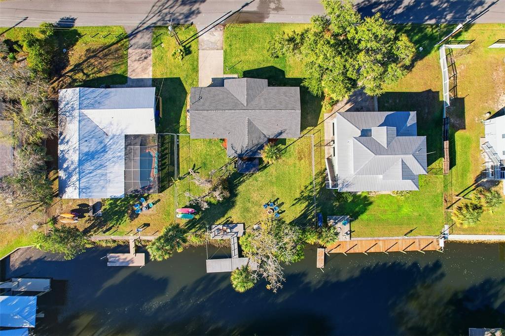An aerial view shows three houses along a canal with docks and grassy yards — 3619 N SUWANNEE POINT, CRYSTAL RIVER, FL