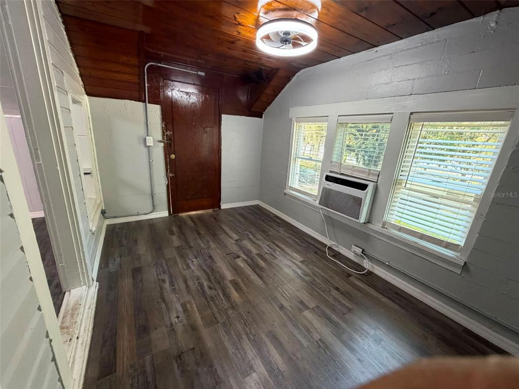 An attic bedroom features gray walls, a sloped ceiling, and dark wood-look flooring — 41014 FLETCHER ROAD, UMATILLA, FL