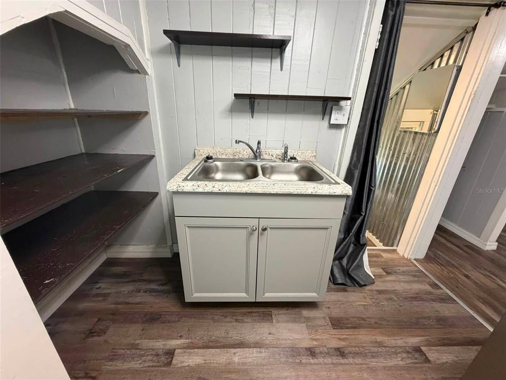 A kitchen features a stainless steel refrigerator, a black stove, gray cabinets, and granite countertops — 41014 FLETCHER ROAD, UMATILLA, FL