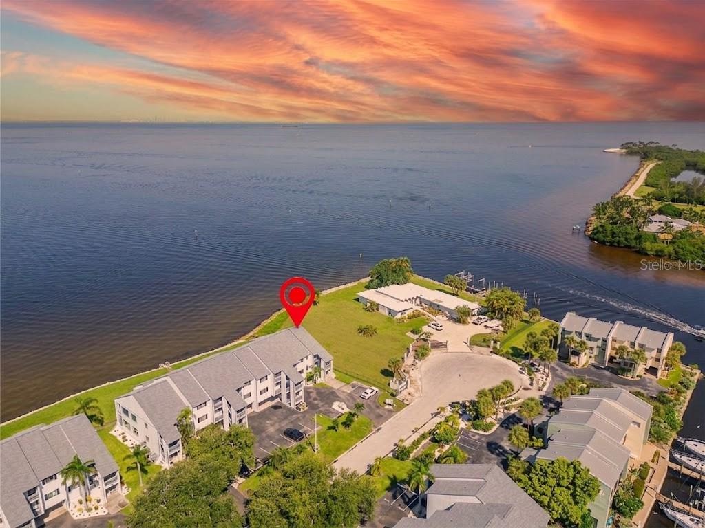 An aerial view shows a waterfront residential complex with a red pin marking a building — 828 BAHIA DEL SOL DRIVE UNIT 59, RUSKIN, FL
