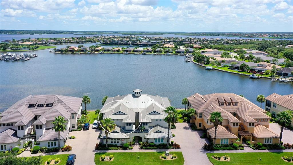 An aerial view of a multi-story house with a metal roof near a canal — 1041 RIVERSCAPE STREET UNIT 1041, BRADENTON, FL
