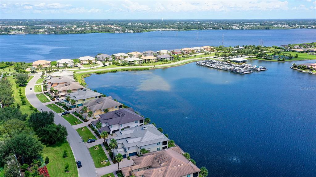 An aerial view shows a multi-story residential building with a white roof near water — 1041 RIVERSCAPE STREET UNIT 1041, BRADENTON, FL