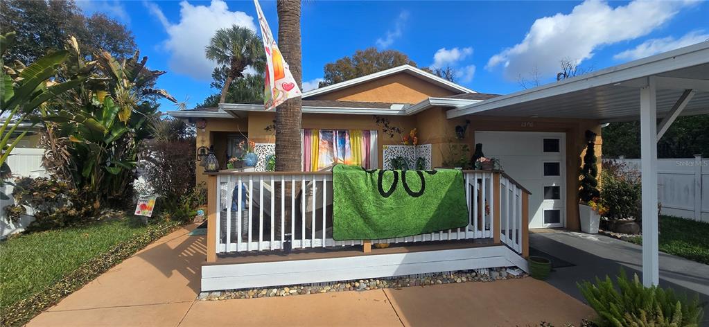A single-story house features a front porch with a green blanket and a carport — 1506 E 28TH AVENUE, TAMPA, FL