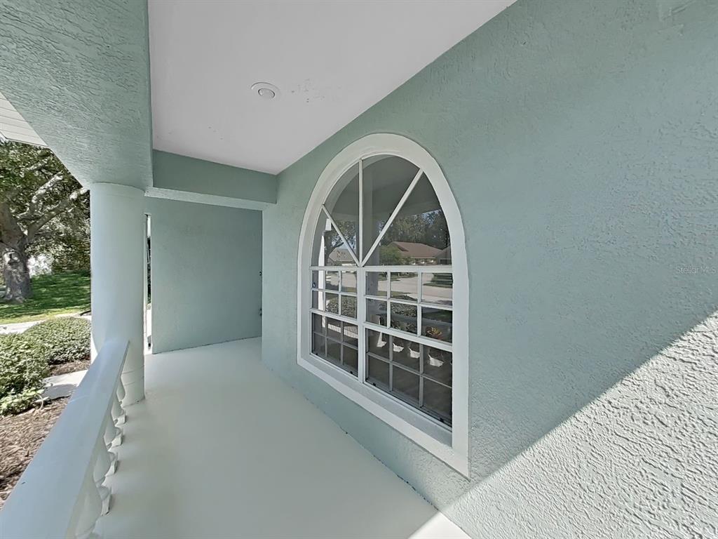 A covered porch with light blue stucco walls and an arched window — 1423 LAKE SHORE RANCH DRIVE, SEFFNER, FL