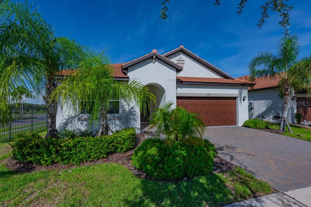 A single-story house with a white stucco exterior, tile roof, and a two-car garage — 17253 STAR BANKS STREET, WIMAUMA, FL