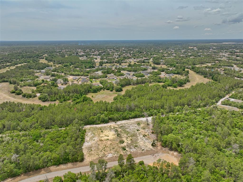 An aerial view shows a cleared rectangular residential lot surrounded by trees and nearby homes — SW 35TH TERRACE, OCALA, FL