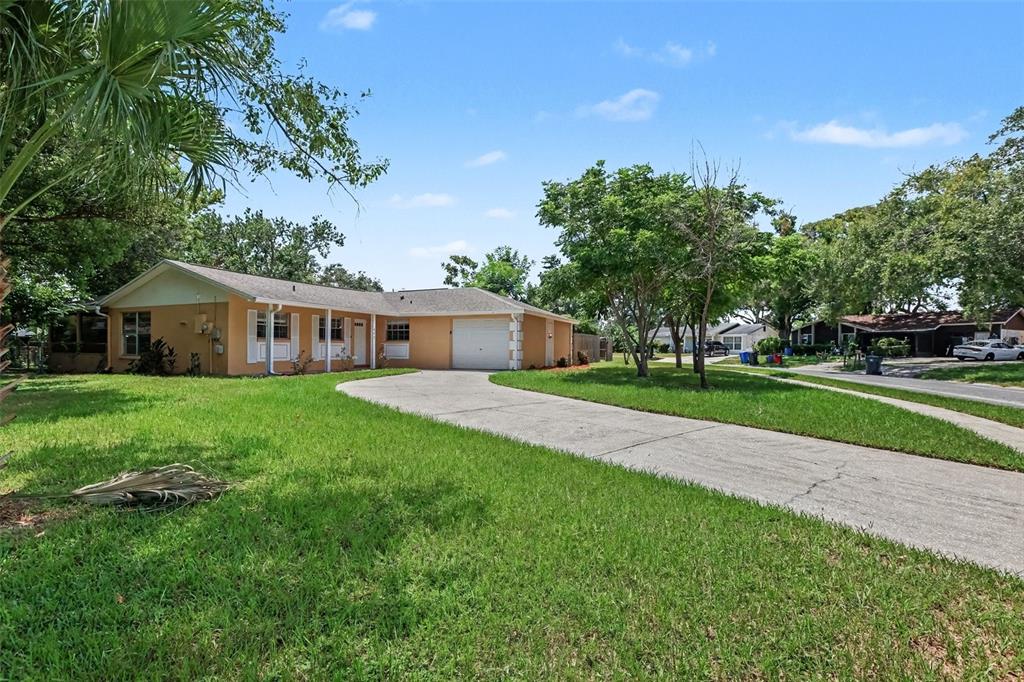 A single-story house with a tan exterior, a concrete driveway, and a one-car garage — 603 HIGHVIEW TERRACE N, BRANDON, FL