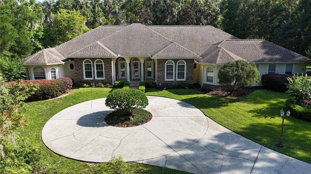 A single-story house with a stone facade and a circular concrete driveway — 1351 SE 91ST PLACE, OCALA, FL