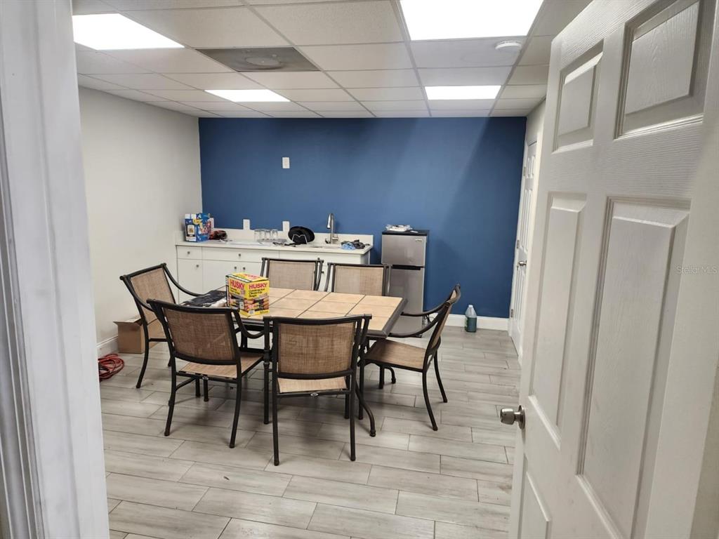 A breakroom features a tiled table with six chairs, a kitchenette, and blue accent wall — 1223 COLUMBIA STREET, ORLANDO, FL