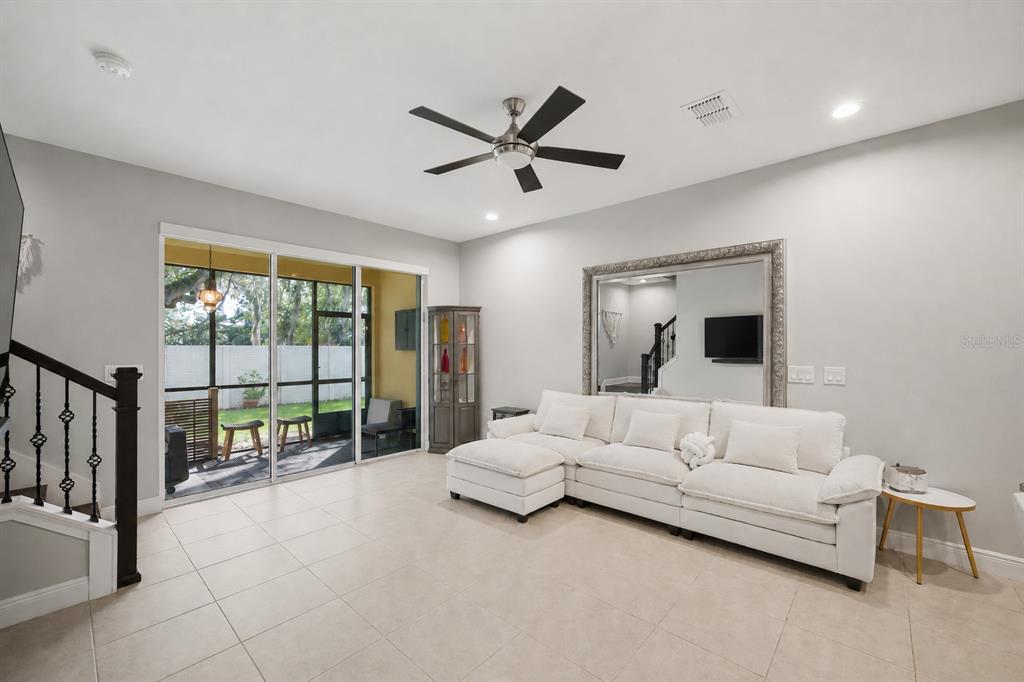A kitchen with dark wood cabinets, granite countertops, a central island, and white bar stools — 2013 SUNSET WIND LOOP, OLDSMAR, FL