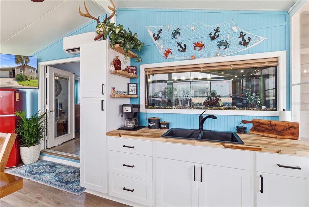 A kitchen with white cabinets, a wood countertop, a black sink, and blue walls — 11639 W CLEARWATER COURT, HOMOSASSA, FL
