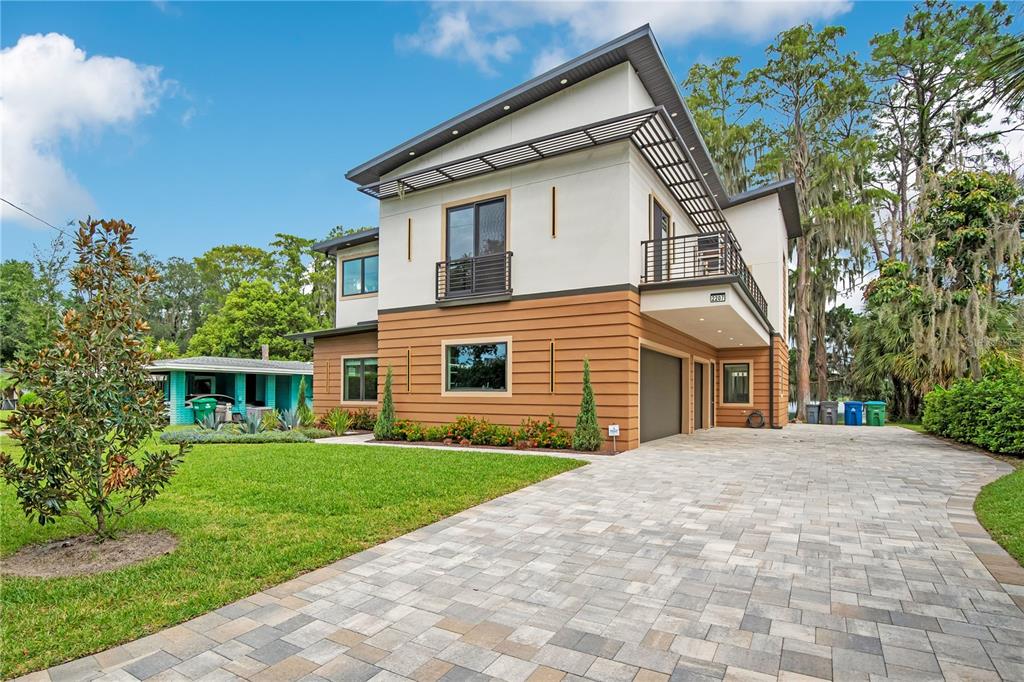 A two-story modern house with horizontal wood siding, white stucco, and a shed-style roof — 2207 KINDEL AVENUE, WINTER PARK, FL
