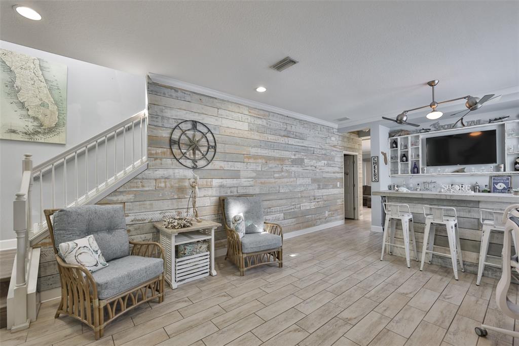A covered front porch with a blue door, two white chairs, and potted plants — 5227 ADMIRAL POINTE DRIVE, APOLLO BEACH, FL