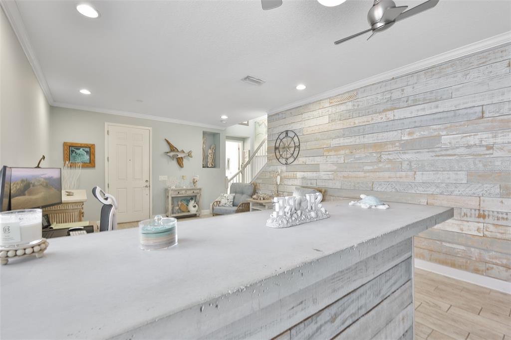 A living room with a sectional sofa and television is open to a white kitchen — 5227 ADMIRAL POINTE DRIVE, APOLLO BEACH, FL