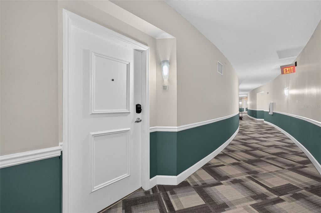 A white door with a digital lock sits in a curved hallway with patterned carpet — 322 E CENTRAL BOULEVARD UNIT 1913, ORLANDO, FL