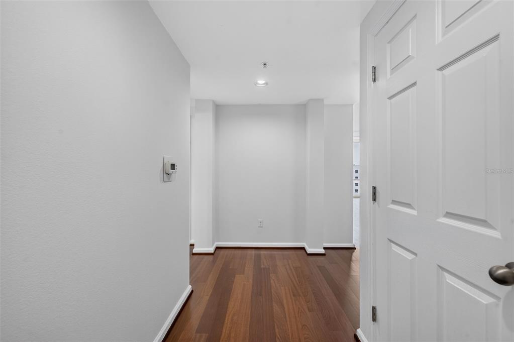 A hallway with hardwood floors leads to an alcove with light gray walls — 322 E CENTRAL BOULEVARD UNIT 1913, ORLANDO, FL