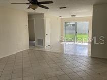 An interior view of a room with tiled floors, a ceiling fan, and sliding glass doors — 11151 IRON BRIDGE ROAD, ORLANDO, FL