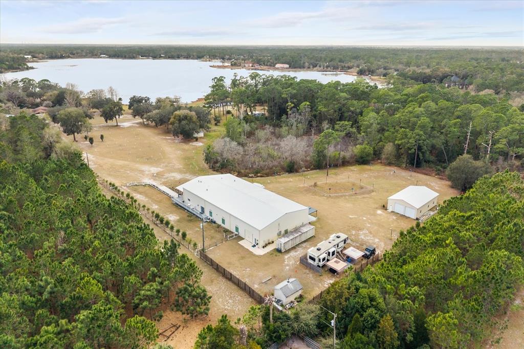 An aerial view shows a large metal building, a detached garage, and an RV on acreage — 455 BRIAR PATCH LANE, GENEVA, FL