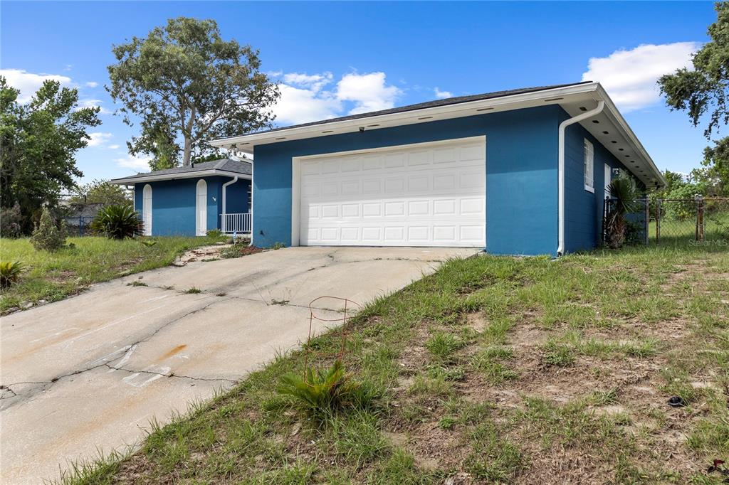 A living room with hardwood floors, white walls, and a television on a small table — 1700 NEEDLEWOOD LANE, ORLANDO, FL