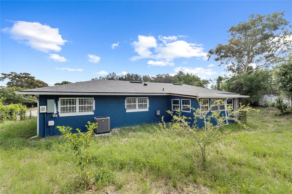 A kitchen with white cabinets, granite countertops, stainless steel appliances, and dark wood flooring — 1700 NEEDLEWOOD LANE, ORLANDO, FL