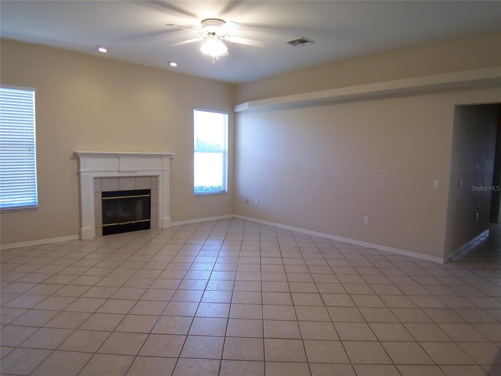 A living room with tile flooring, a fireplace, and a ceiling fan — 5435 SUMMERLAND HILLS DRIVE, LAKELAND, FL