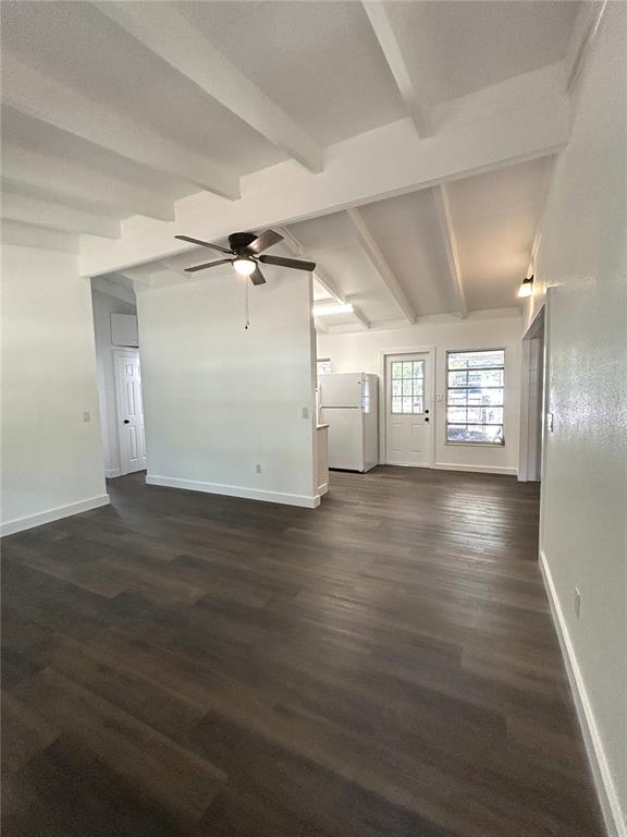 An open-concept living area features white vaulted ceilings, dark wood-look flooring, and a white refrigerator — 34798 EVERGREEN WAY, DADE CITY, FL