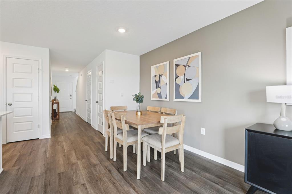 A dining area features a wooden table with four chairs against a gray accent wall — 4706 TONY STREET, LAKE WALES, FL