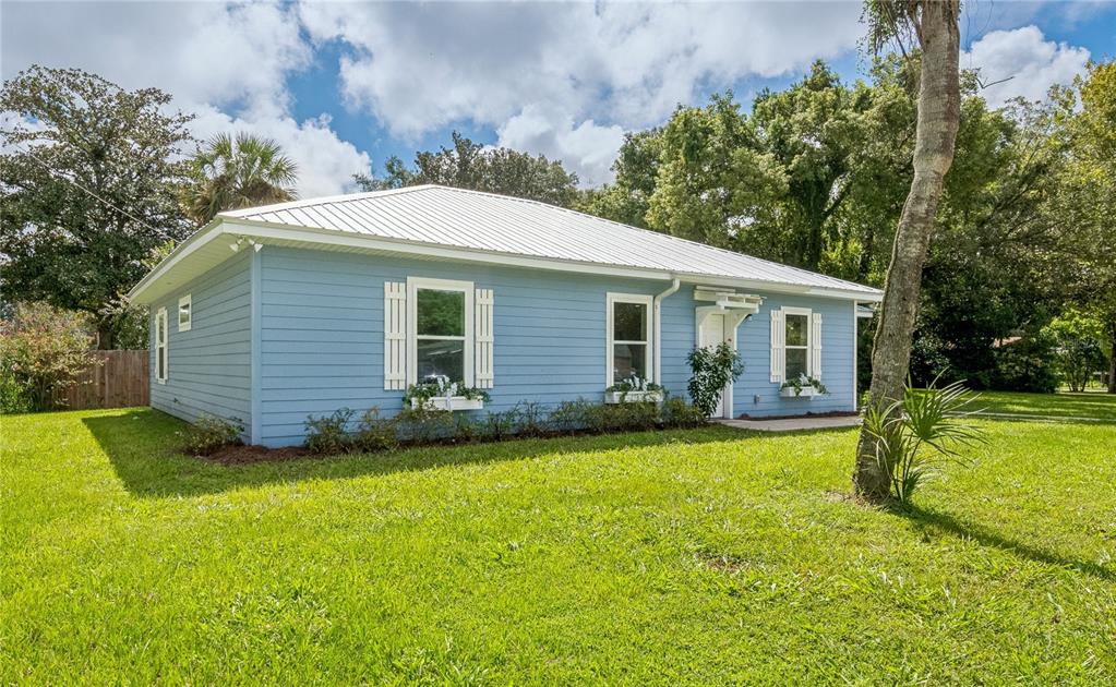 A light blue single-story house with a white metal roof and window boxes — 506 NE FOURTH STREET, TRENTON, FL