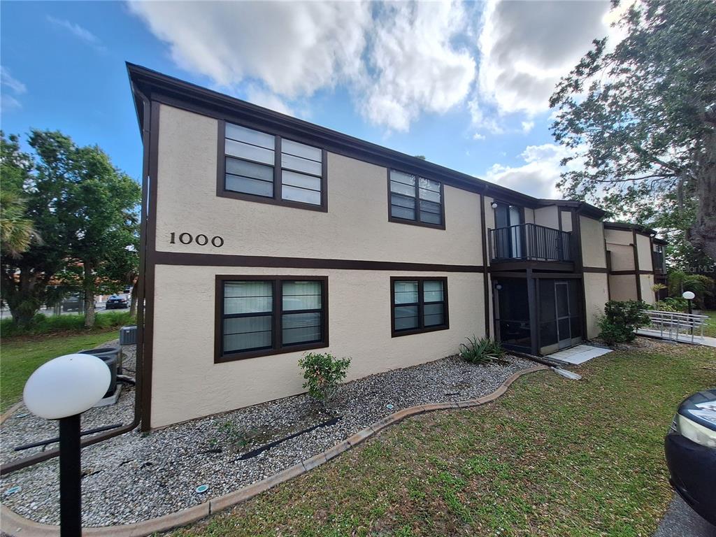 A two-story tan apartment building with brown trim and a screened-in balcony — 4022 BEAVER LANE UNIT 1000G, PORT CHARLOTTE, FL