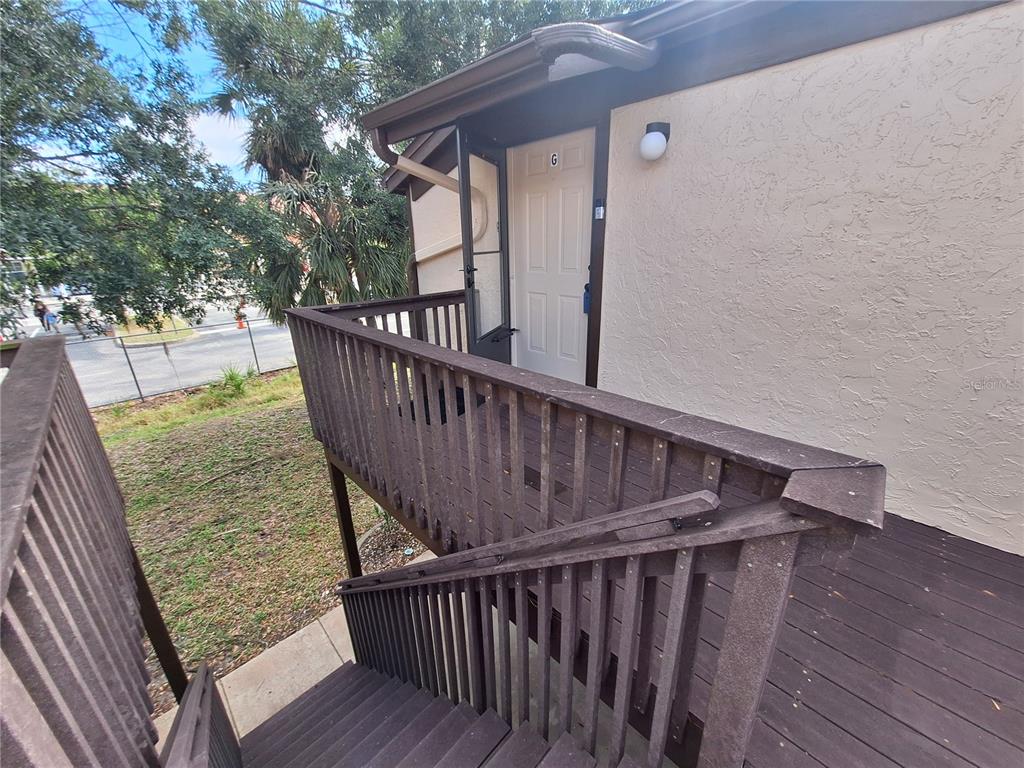 An exterior view of a wooden staircase leading to a second-story apartment entrance — 4022 BEAVER LANE UNIT 1000G, PORT CHARLOTTE, FL