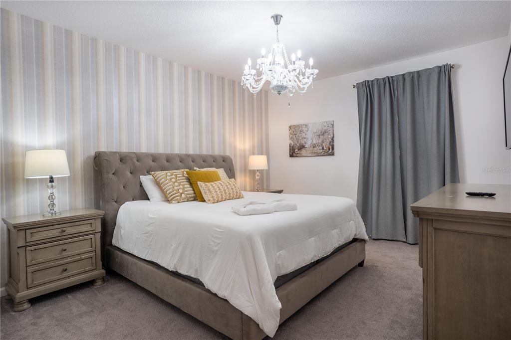 A bedroom features two beds, a large Mickey Mouse wall mural, and black-and-white striped decor — 2610 TRANQUILITY WAY, KISSIMMEE, FL