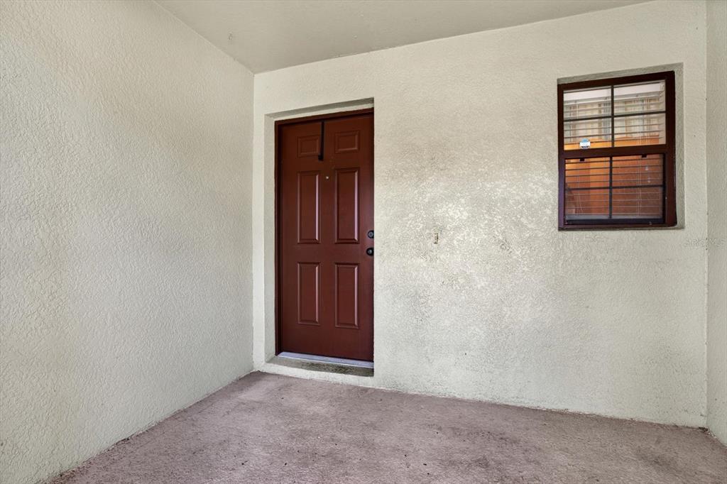 A covered entryway features a brown door and a window with security bars — 2630 EDGEWATER FALLS DRIVE UNIT 0, BRANDON, FL