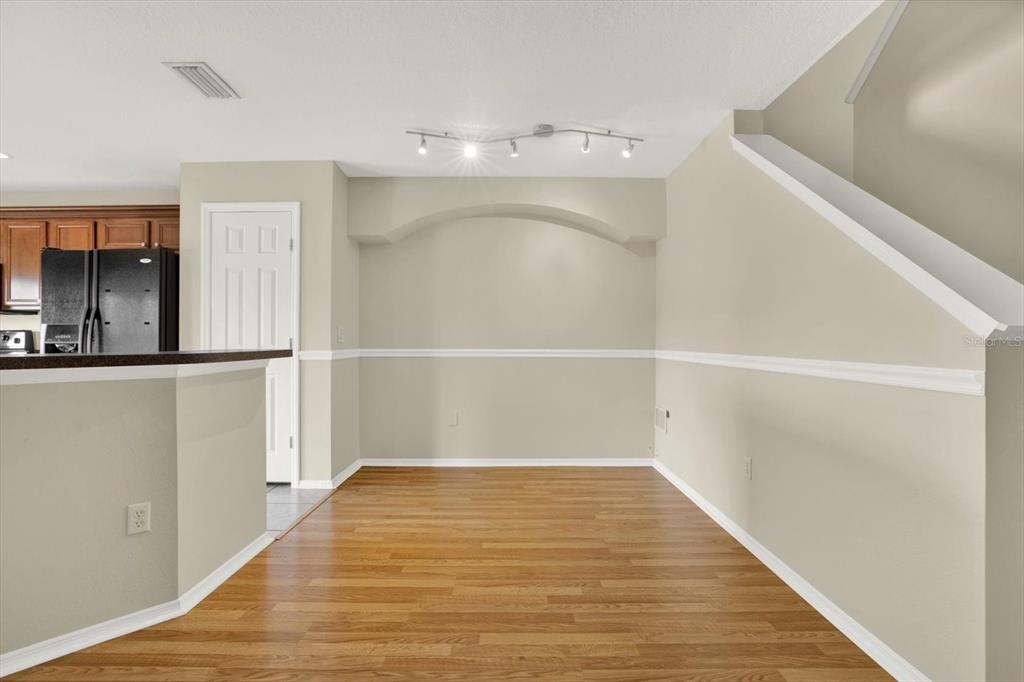 An empty dining area features hardwood floors, beige walls with chair rail molding, and an archway — 2630 EDGEWATER FALLS DRIVE UNIT 0, BRANDON, FL