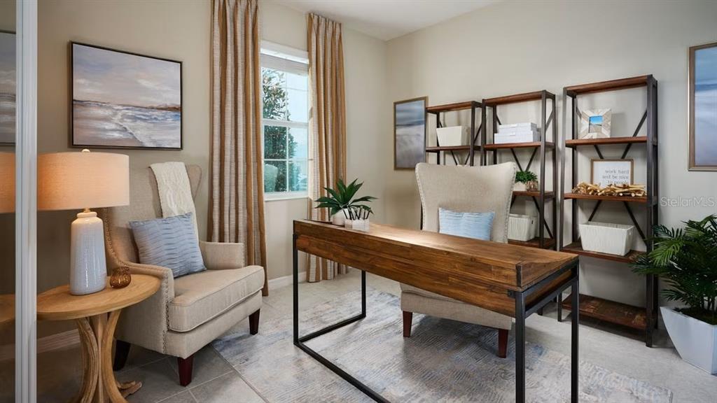 A home office features a wooden desk, two upholstered chairs, shelving units, and a window — 796 GRAZIE LOOP, DAVENPORT, FL