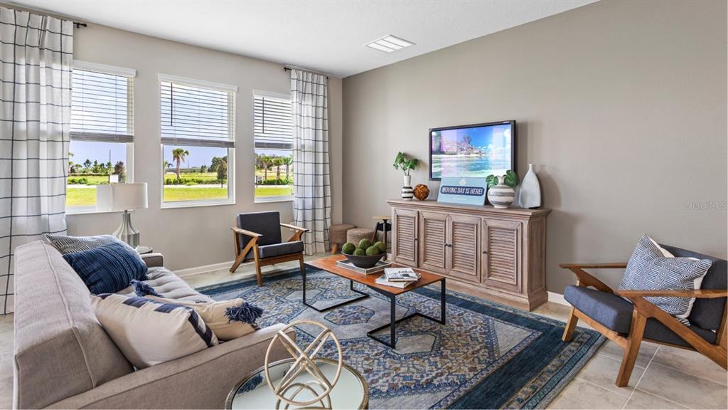 A living room features a grey sofa, two armchairs, a wooden console, and a patterned rug — 1106 JAMES PAUL RD, DAVENPORT, FL