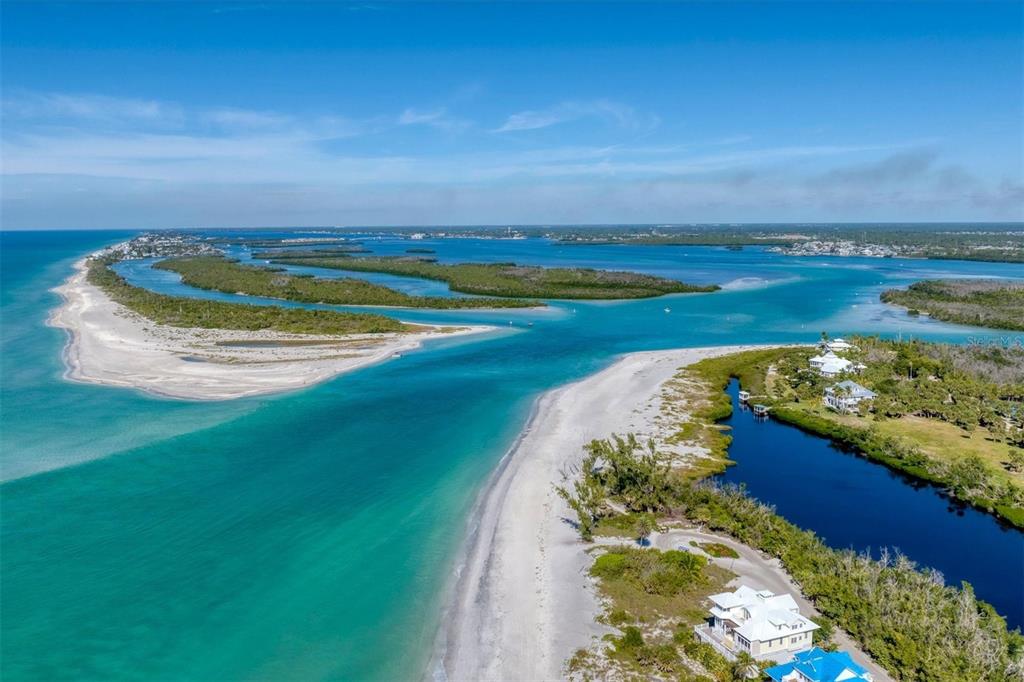 An aerial view of a sandy beach inlet separating two coastal landmasses with turquoise water — 6920 PALM ISLAND DRIVE, PLACIDA, FL