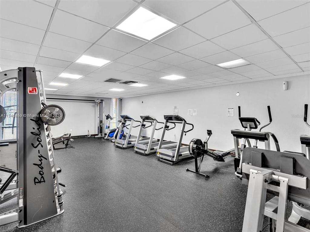 A gym room features several treadmills, a rowing machine, and a Body-Solid weight training station — 3750 NE 170TH STREET UNIT 311, NORTH MIAMI BEACH, FL