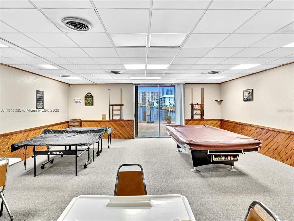 A recreation room features a ping pong table, a pool table, and sliding glass doors — 3750 NE 170TH STREET UNIT 311, NORTH MIAMI BEACH, FL