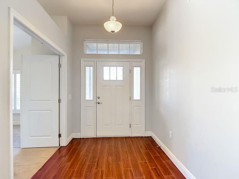An entryway features a white front door with sidelights, a transom window, and wood flooring — 12244 LOOPBACK DRIVE, SAN ANTONIO, FL