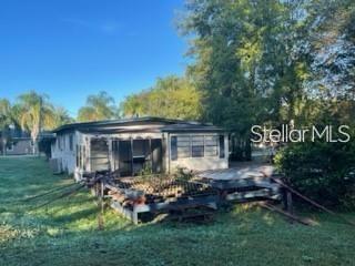 A single-story house with a screened-in porch and a wooden deck in a grassy yard — 1501 PEARL STREET, LONGWOOD, FL