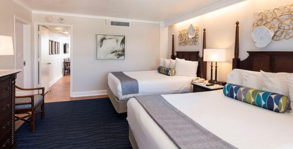 A hotel bedroom features two queen beds, dark wood furniture, and a blue patterned rug — 5500 GULF BOULEVARD UNIT 2249, ST PETE BEACH, FL