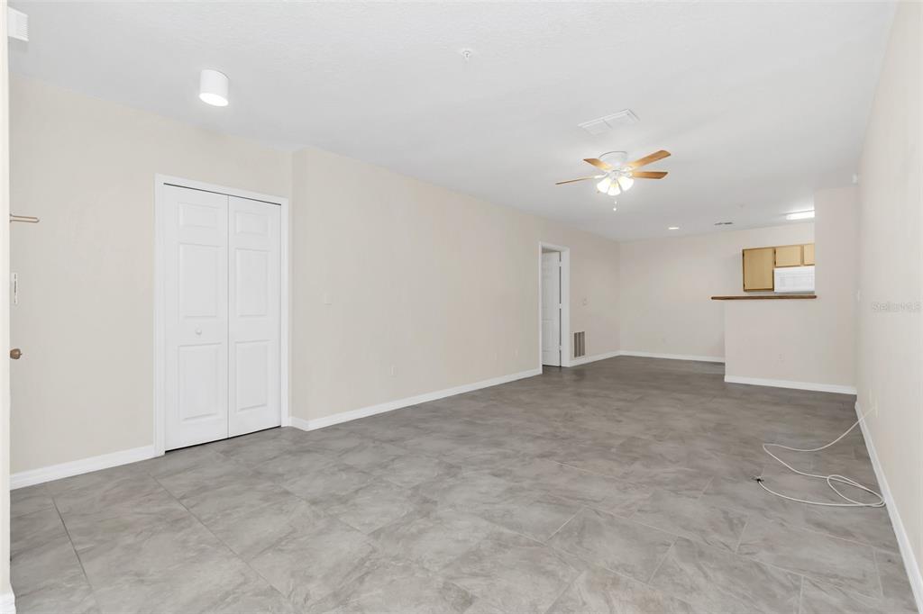 An empty room with light-colored walls, gray tile flooring, a ceiling fan, and closet doors — 4328 S KIRKMAN ROAD UNIT 1311, ORLANDO, FL