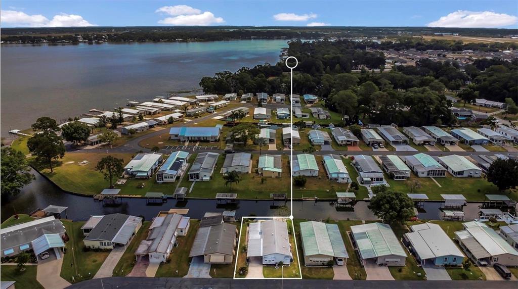 An aerial view shows a manufactured home community with a highlighted waterfront residence — 119 JANA CIRCLE, AUBURNDALE, FL