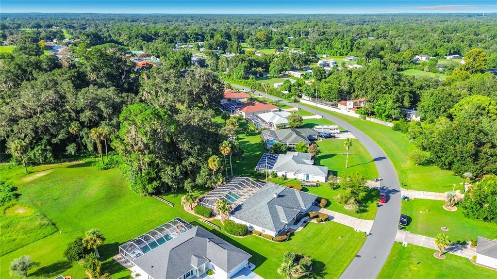 An aerial view shows several suburban houses with swimming pools surrounded by trees and lawns — 1281 N TIMUCUAN TRAIL, INVERNESS, FL