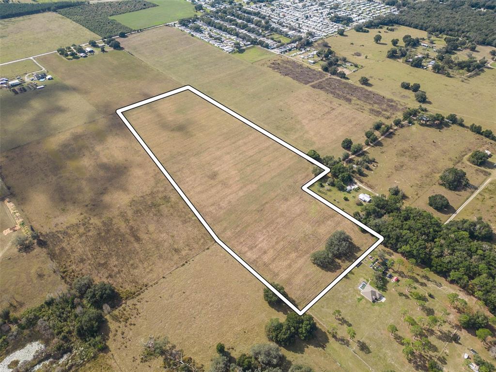 An aerial view shows a large, irregularly shaped plot of vacant land outlined in white — BUR MAC ROAD, DADE CITY, FL