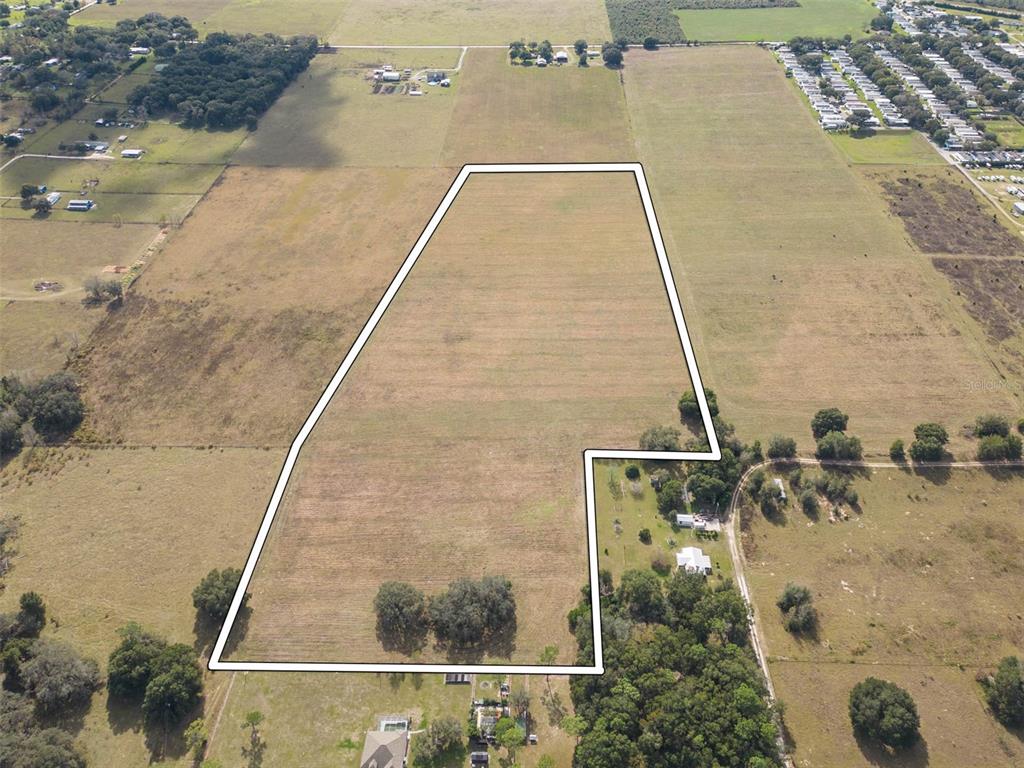 An aerial view shows a large, irregularly shaped plot of open land outlined in white — BUR MAC ROAD, DADE CITY, FL