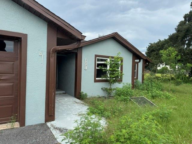 A light blue house with brown trim and overgrown grass in the front yard — 2231 CR 543, SUMTERVILLE, FL